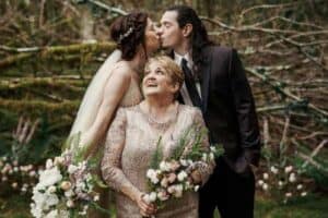 Mother Of The Groom Speech - Bride & Groom Kissing With Mother In Photo