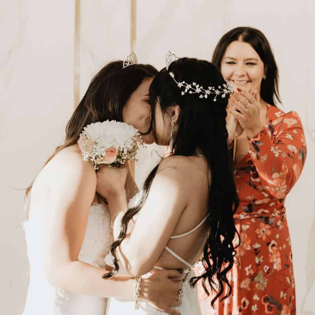 Lesbian brides making their wedding vows and kissing.