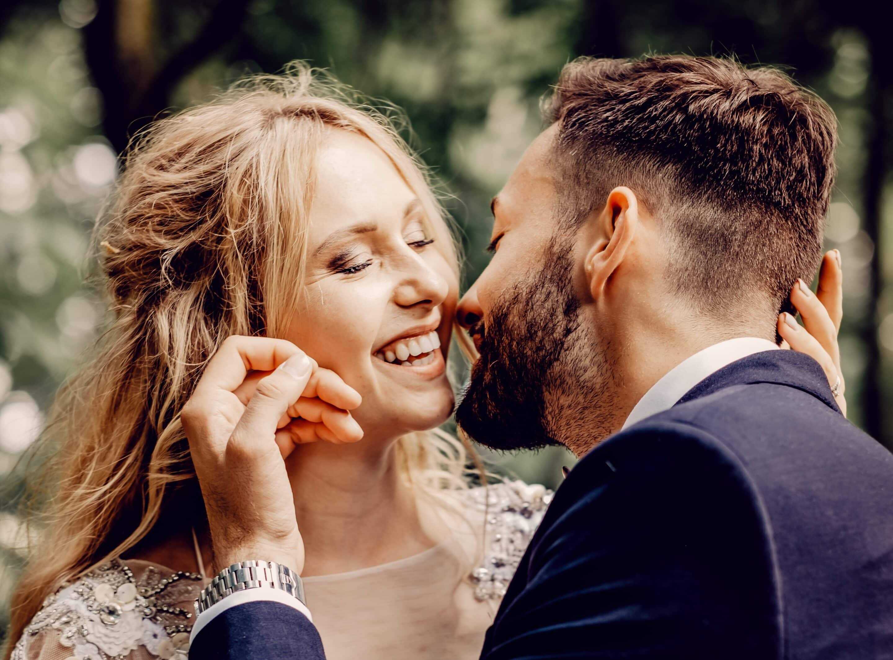 Bride and groom smiling and going in for a kiss