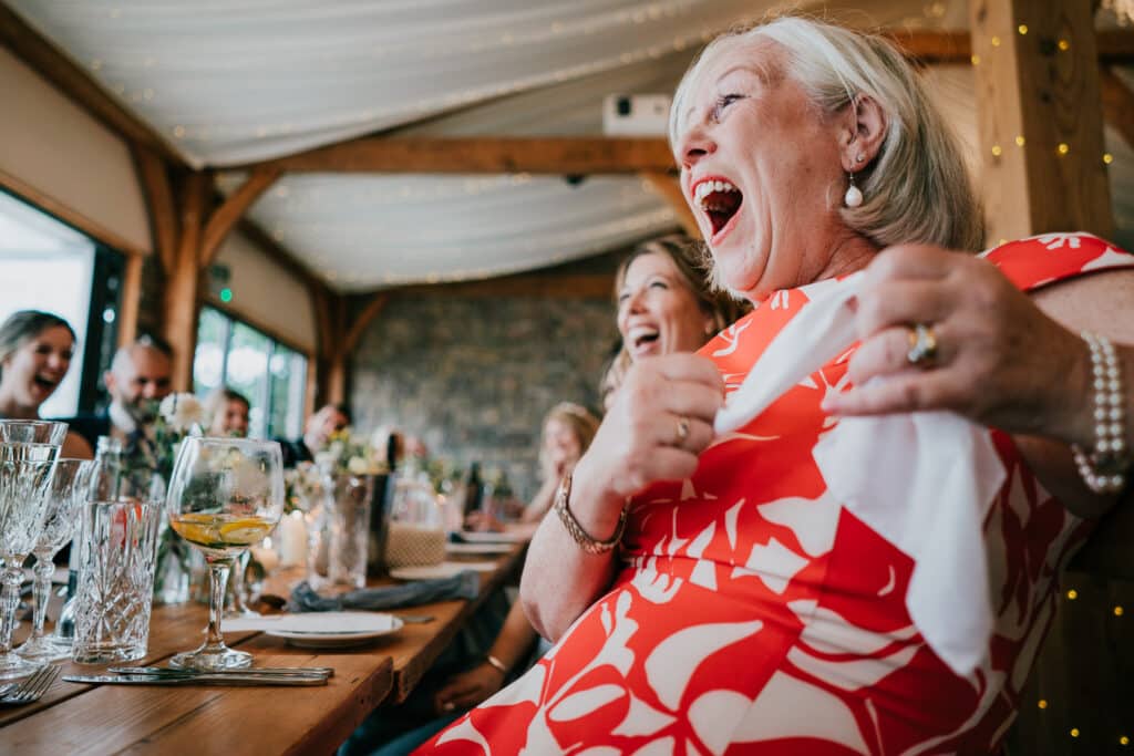people laughing at the wedding speech