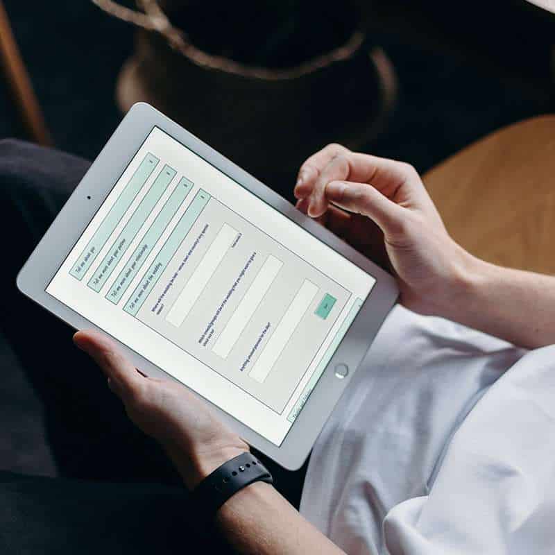 A man using an AI wedding speech generating software on his tablet. The screen we can see is from SpeechyAI.