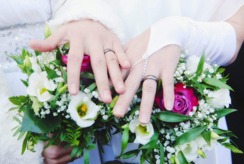 Lesbian brides showing their wedding rings.
