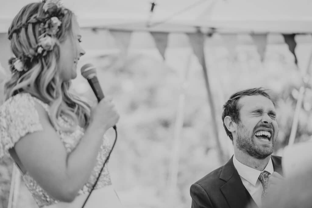 groom laughing at the bride's speech