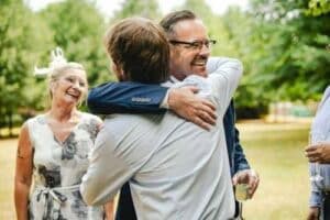 father of the groom hugging his son