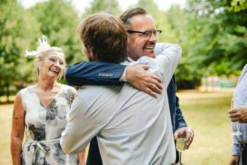 father of the groom hugging his son