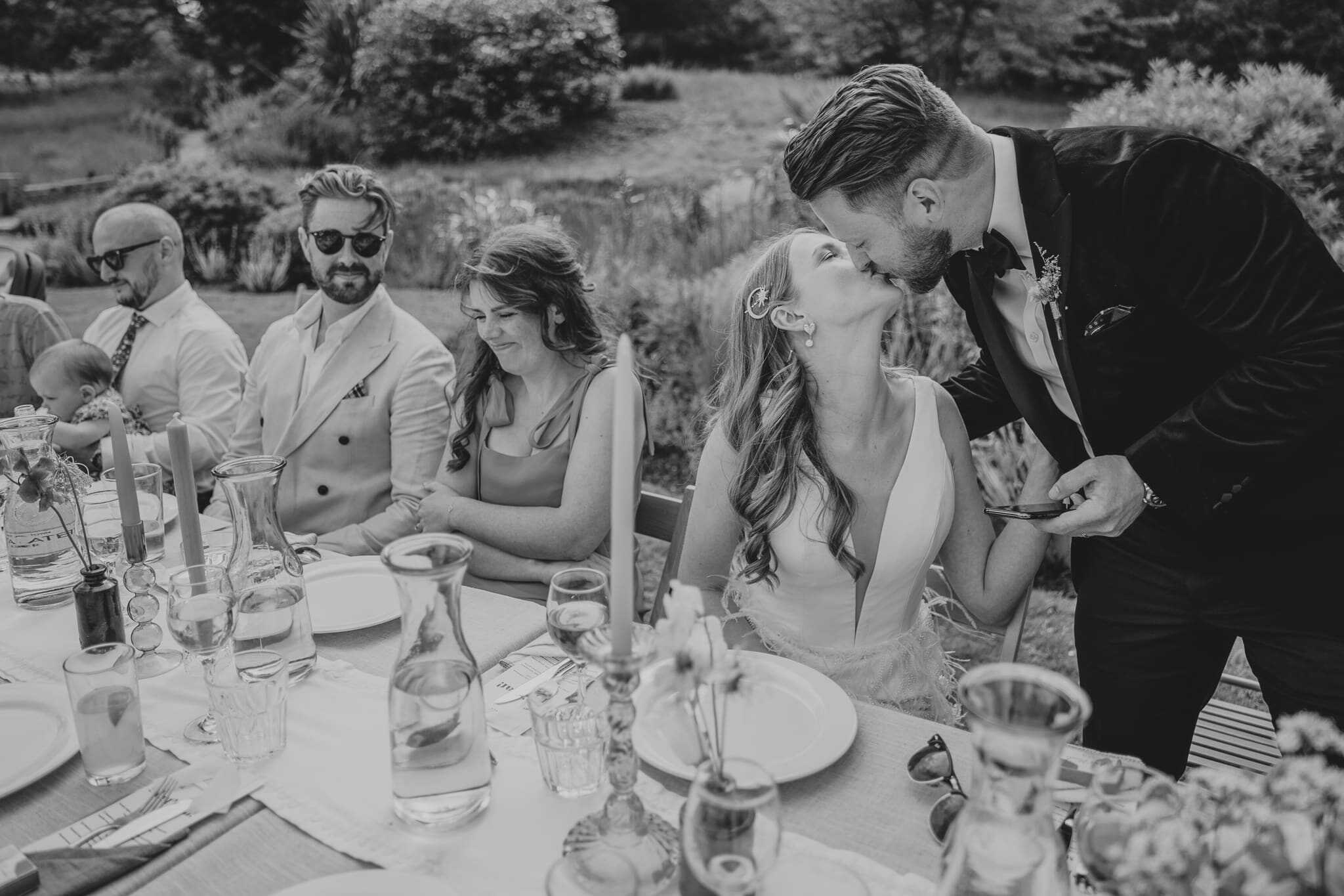 happy groom kissing bride after delivering his speech